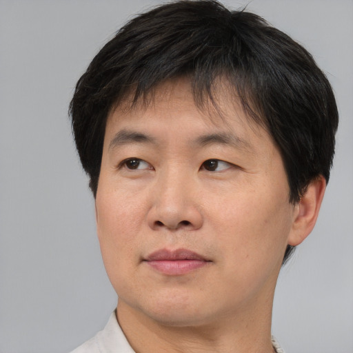 Joyful asian adult male with short  brown hair and brown eyes