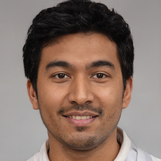 Joyful latino young-adult male with short  black hair and brown eyes
