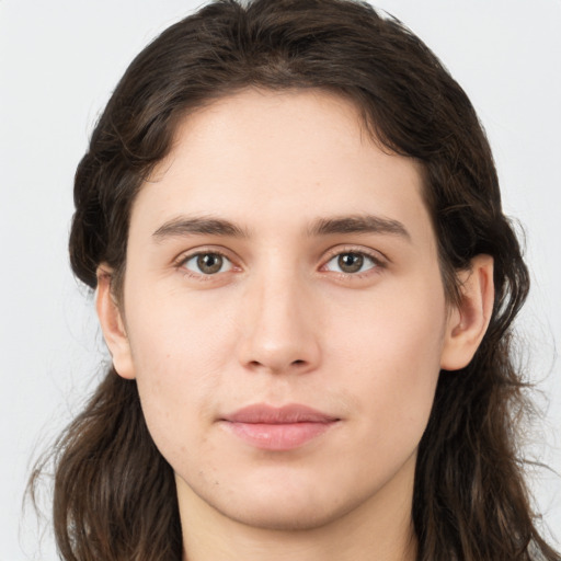 Joyful white young-adult male with long  brown hair and brown eyes