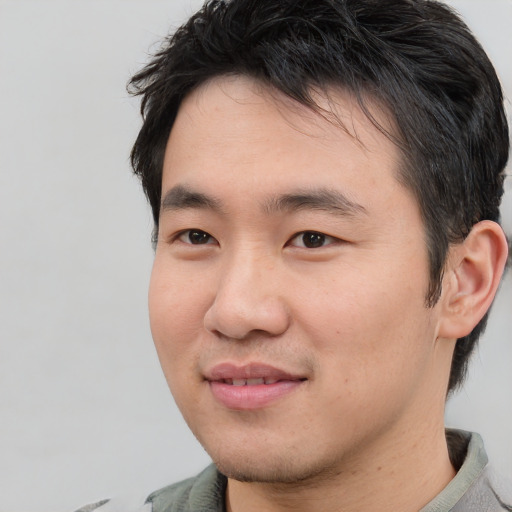 Joyful asian young-adult male with short  black hair and brown eyes