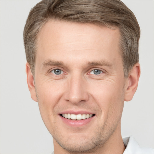 Joyful white adult male with short  brown hair and grey eyes