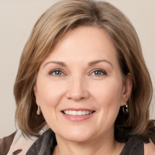 Joyful white adult female with medium  brown hair and grey eyes