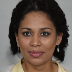 Joyful latino adult female with medium  brown hair and brown eyes