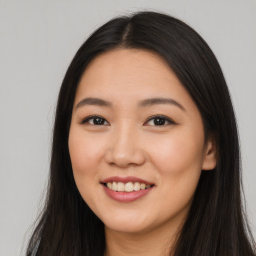 Joyful asian young-adult female with long  brown hair and brown eyes