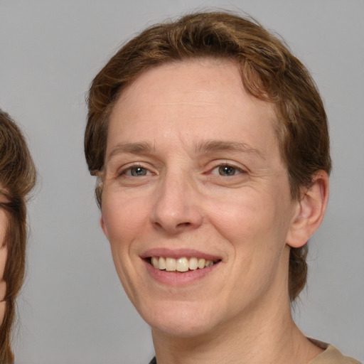 Joyful white adult female with medium  brown hair and brown eyes