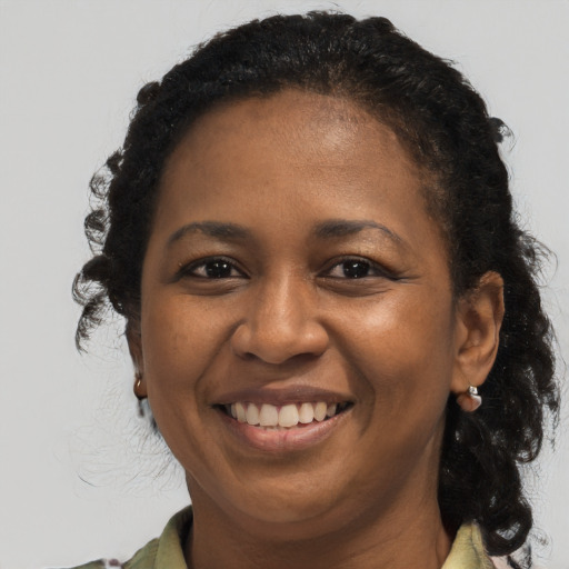 Joyful black adult female with long  brown hair and brown eyes