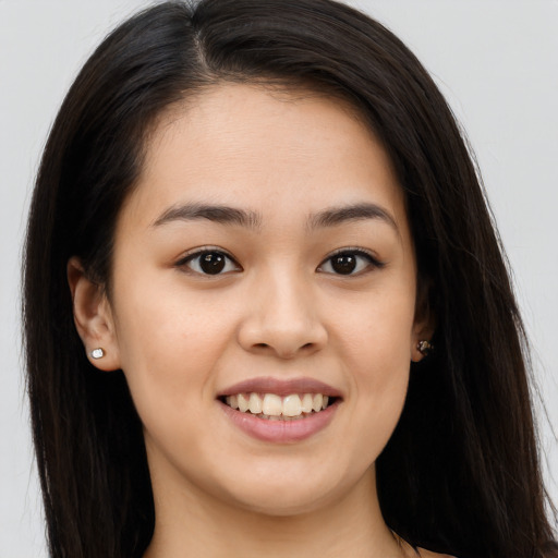 Joyful asian young-adult female with long  brown hair and brown eyes