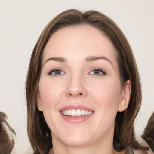 Joyful white young-adult female with long  brown hair and grey eyes