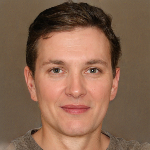 Joyful white adult male with short  brown hair and grey eyes