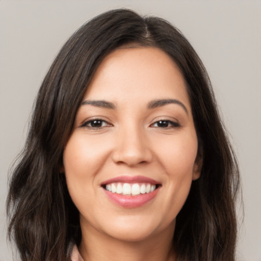 Joyful white young-adult female with long  brown hair and brown eyes