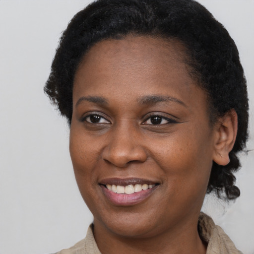 Joyful black young-adult female with short  brown hair and brown eyes