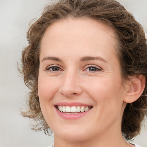 Joyful white young-adult female with medium  brown hair and green eyes