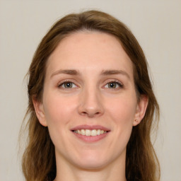 Joyful white young-adult female with long  brown hair and green eyes