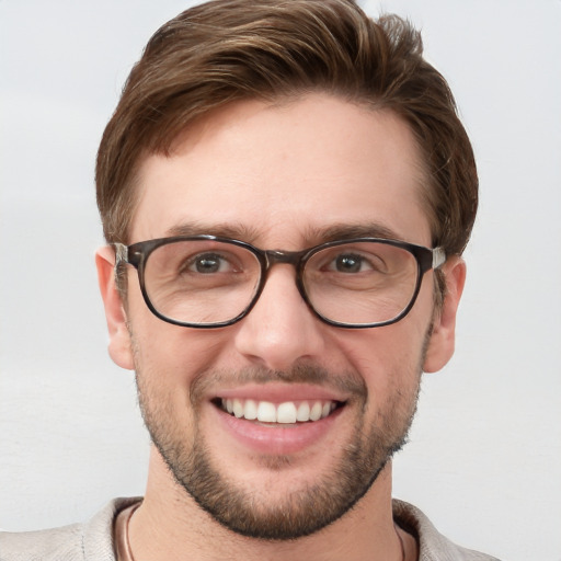 Joyful white young-adult male with short  brown hair and blue eyes