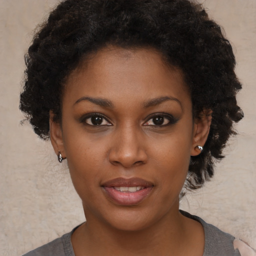 Joyful black young-adult female with short  brown hair and brown eyes