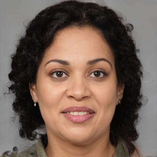 Joyful latino adult female with medium  brown hair and brown eyes