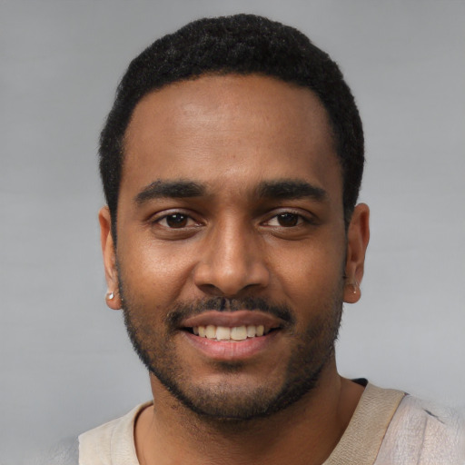 Joyful black young-adult male with short  black hair and brown eyes