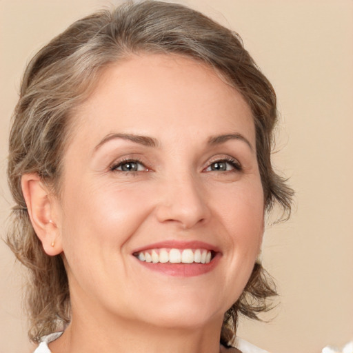 Joyful white young-adult female with medium  brown hair and grey eyes