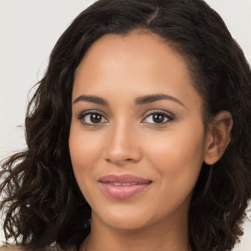 Joyful latino young-adult female with long  brown hair and brown eyes