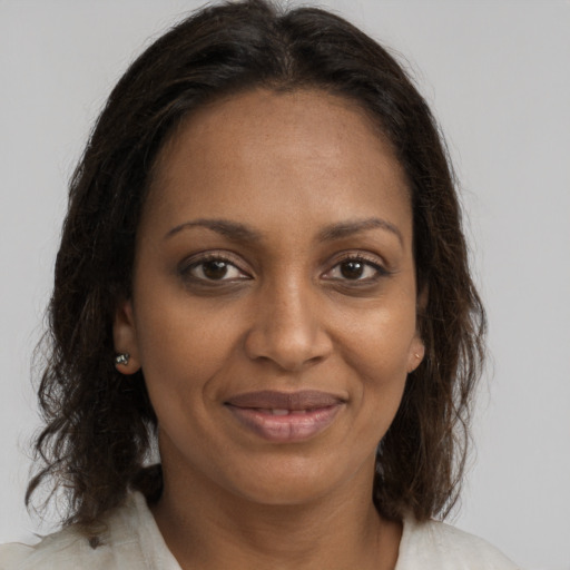 Joyful black adult female with medium  brown hair and brown eyes