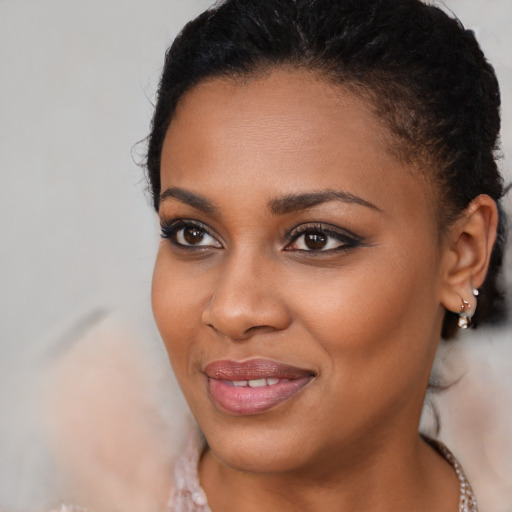 Joyful black young-adult female with long  brown hair and brown eyes