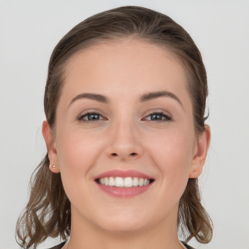 Joyful white young-adult female with long  brown hair and grey eyes