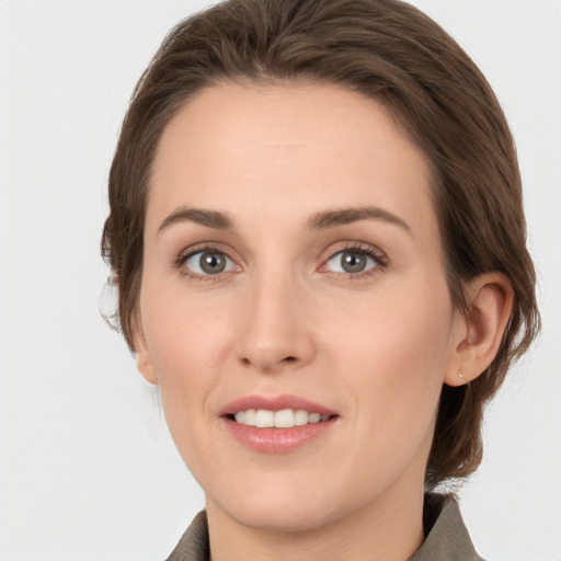 Joyful white young-adult female with medium  brown hair and grey eyes