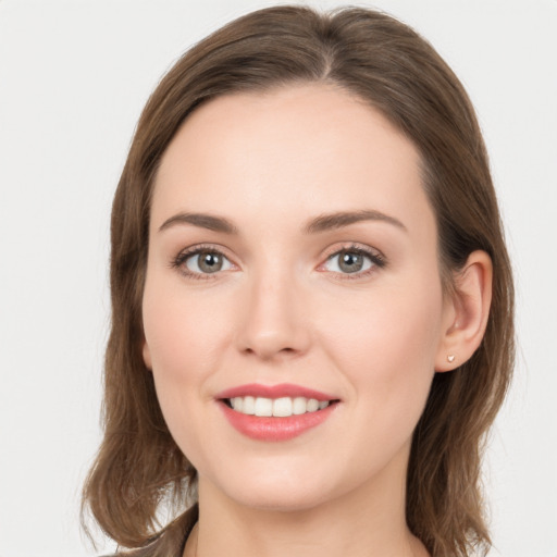 Joyful white young-adult female with long  brown hair and green eyes