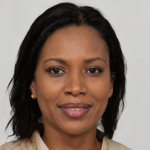 Joyful black adult female with long  brown hair and brown eyes