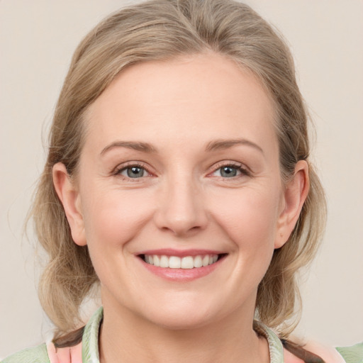 Joyful white young-adult female with medium  brown hair and blue eyes