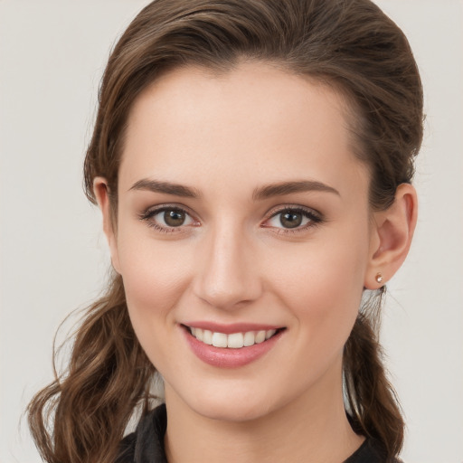 Joyful white young-adult female with long  brown hair and grey eyes