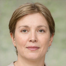 Joyful white adult female with medium  brown hair and green eyes