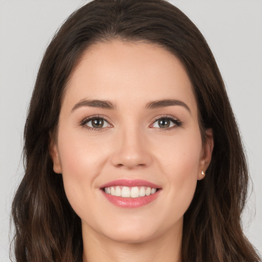 Joyful white young-adult female with long  brown hair and brown eyes