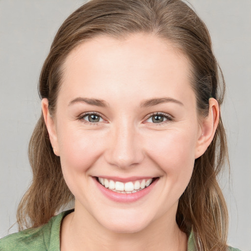 Joyful white young-adult female with medium  brown hair and grey eyes