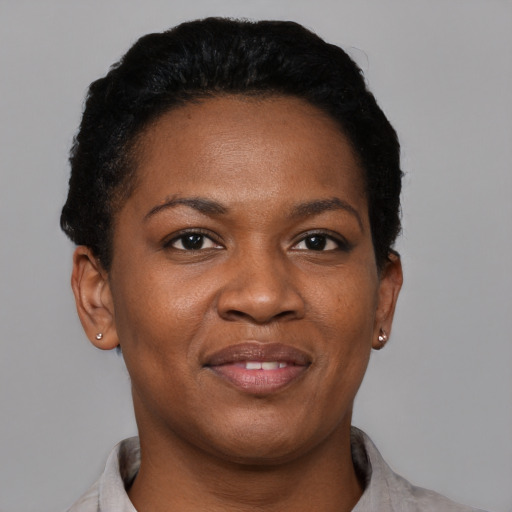 Joyful black young-adult female with short  black hair and brown eyes