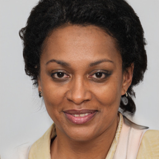 Joyful black adult female with long  brown hair and brown eyes