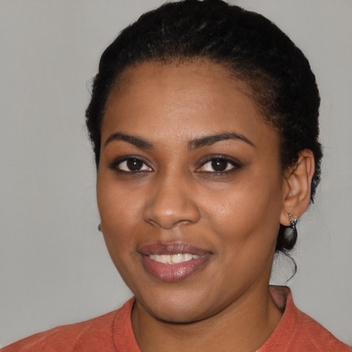 Joyful black young-adult female with short  black hair and brown eyes