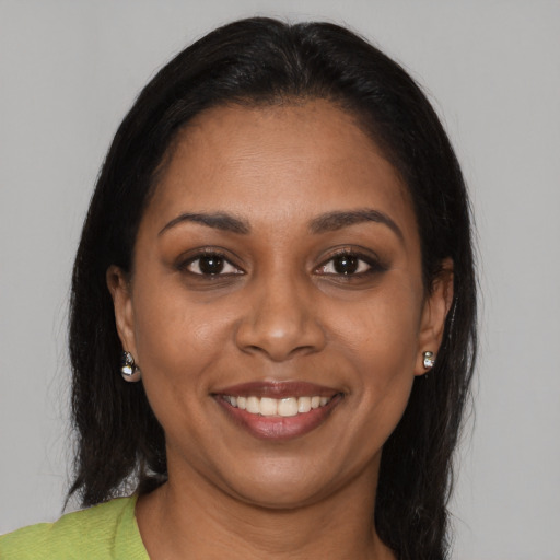 Joyful black young-adult female with long  brown hair and brown eyes