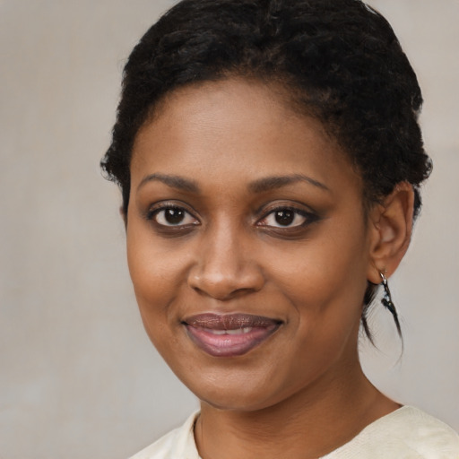Joyful black young-adult female with short  black hair and brown eyes