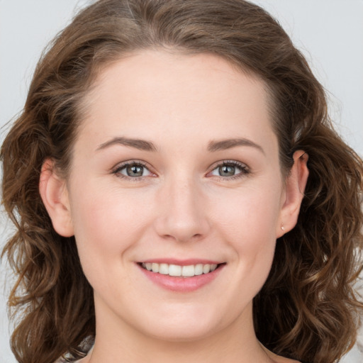 Joyful white young-adult female with medium  brown hair and green eyes