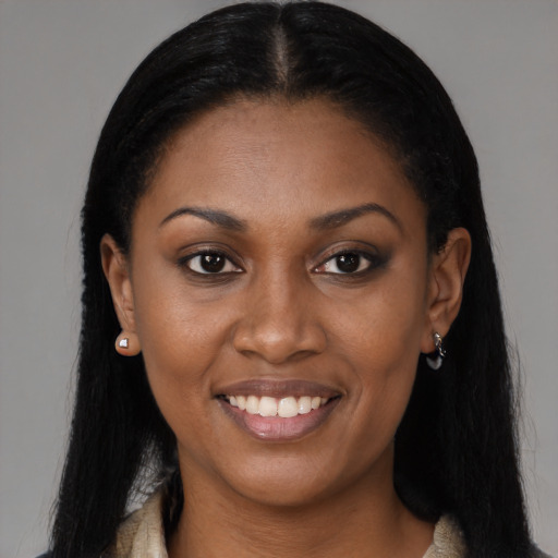 Joyful black young-adult female with long  brown hair and brown eyes