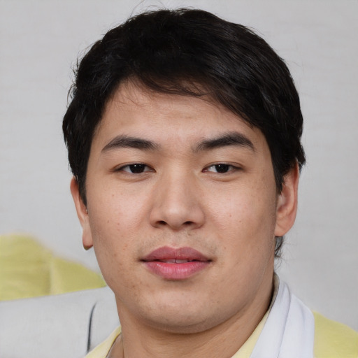 Joyful asian young-adult male with short  brown hair and brown eyes