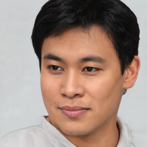 Joyful asian young-adult male with short  brown hair and brown eyes