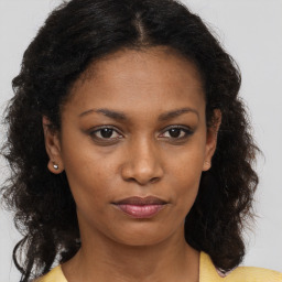 Joyful black young-adult female with medium  brown hair and brown eyes