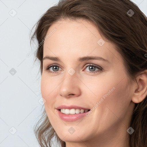 Joyful white young-adult female with long  brown hair and grey eyes