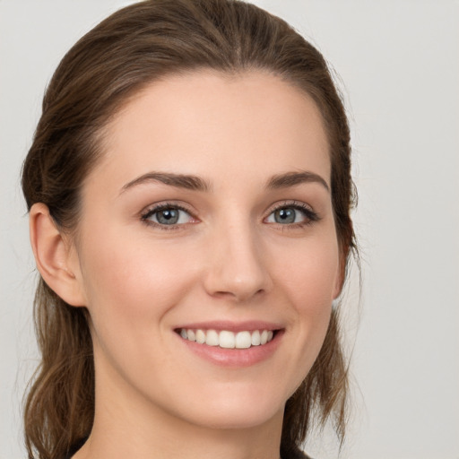 Joyful white young-adult female with long  brown hair and grey eyes