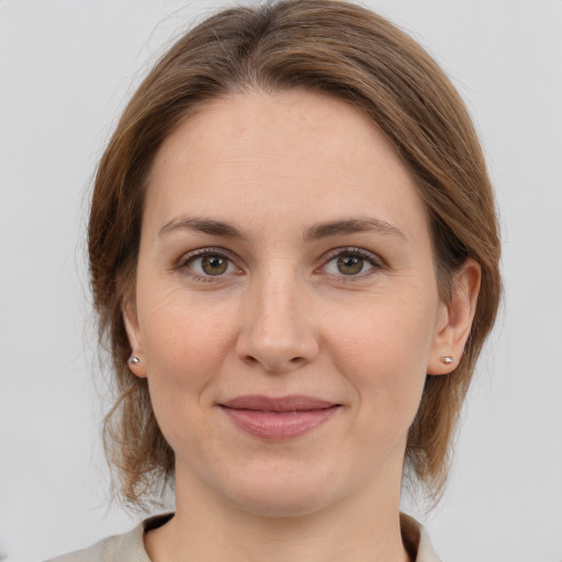 Joyful white young-adult female with medium  brown hair and grey eyes