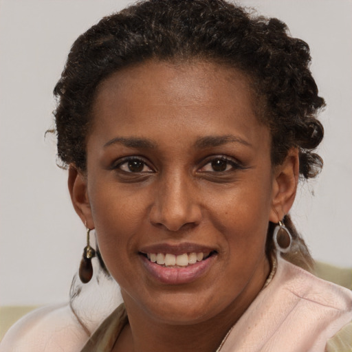 Joyful black young-adult female with short  brown hair and brown eyes
