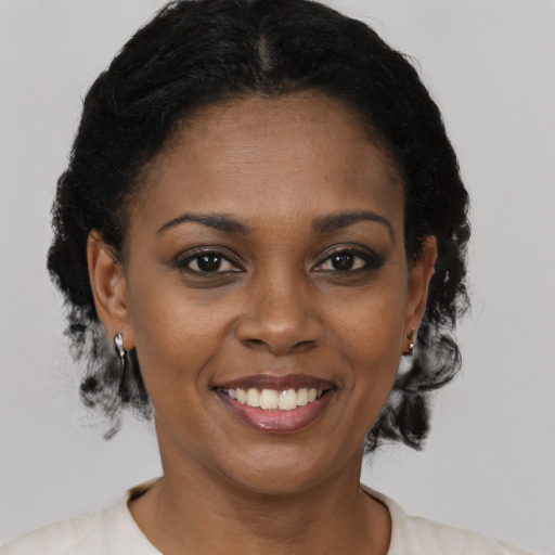 Joyful black young-adult female with short  brown hair and brown eyes