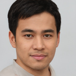 Joyful latino young-adult male with short  brown hair and brown eyes